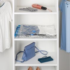 a white book shelf with clothes and purses on it, next to a blue handbag