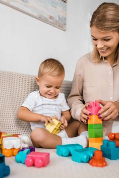 a woman and child playing with blocks on the floor