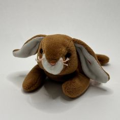 a brown stuffed rabbit sitting on top of a white table