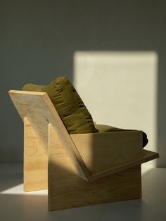 a wooden chair sitting on top of a white floor next to a wall and window