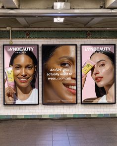 three billboards in a subway station advertising beauty products