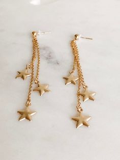 These lightweight celestial earrings feature three chain cascades with star charms. Fun and chic, these will take you from day to night without missing a beat! DETAILS * 14kt gold filled cable chain * total length is 85 mm/3.25" * 14kt gold filled post studs SHIPPING: ✤I offer FREE shipping within Canada but please note that this does NOT include tracking. If you choose FREE shipping, you risk your package getting lost in transit. If this happens, I CANNOT issue you a refund or replace your jewe Dainty Star Charm Drop Earrings, Star Shaped Earrings With Adjustable Chain For Gifts, Gold Drop Earrings With Star Charm, Celestial Style Dangle Earrings With Star Charm, Cute Star Charm Dangle Earrings, Star-shaped Earrings With Adjustable Chain As Gift, Gold Star-shaped Jewelry With Dangling Charms, Star Dangle Earrings, Gold Chain Earrings