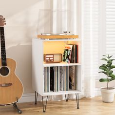 a small wooden shelf with some records and a guitar