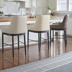 three chairs sitting in front of a kitchen counter