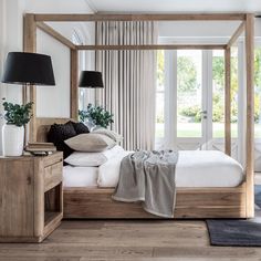 a bedroom with a four poster bed and two lamps on either side of the bed