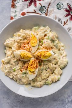 a white bowl filled with some kind of food on top of a blue table cloth