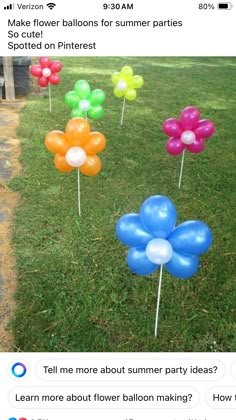 some balloons that are in the grass and one is on top of another balloon stick