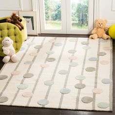 a white rug with grey circles on it and two teddy bears sitting in the corner