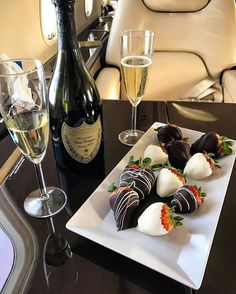 chocolate covered strawberries and champagne are on a table