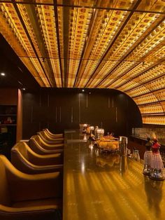 the interior of a restaurant with rows of chairs and yellow lights hanging from the ceiling