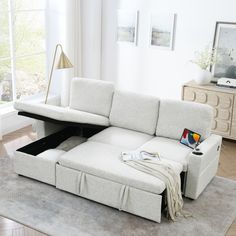 a living room with a white couch and coffee table in the middle, on top of a rug