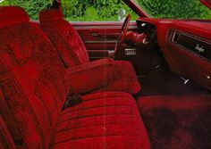 the interior of an old car with red upholstered seats