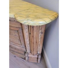 a wooden cabinet with yellow marble top in a corner by the wall and hardwood flooring