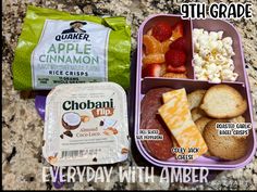 two lunch boxes filled with different types of food on a granite counter top next to each other