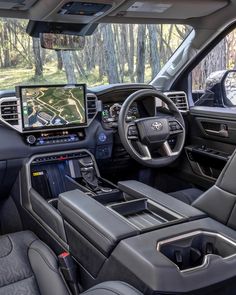 the interior of a vehicle with dashboard, steering wheel and touch screen monitor showing driving directions