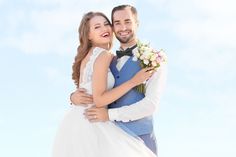 a man in a tuxedo is hugging a woman wearing a white wedding dress