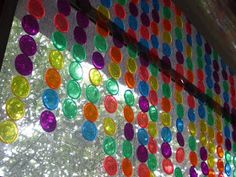 colorful circles are hanging on the side of a window with sequins all over it