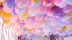 a room filled with lots of balloons hanging from the ceiling