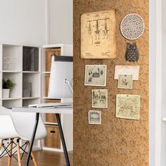 a cork board with pictures and post it notes attached to the wall next to a desk