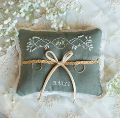 a green pillow with a pair of scissors tied to it on a lace covered surface