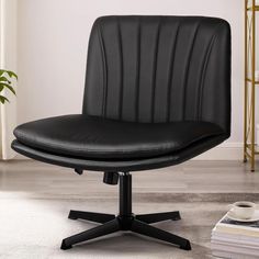 a black office chair sitting on top of a white rug next to a potted plant