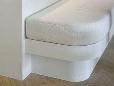 a white bench sitting on top of a hard wood floor