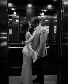 a man and woman are kissing in an elevator