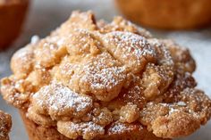 a muffin with powdered sugar on top is sitting in front of other muffins