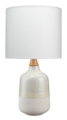 a white and gold lamp with a white shade on it's base, against a white background