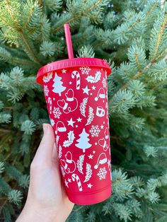 a hand holding a red cup with christmas decorations on it