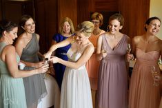 a group of women standing next to each other holding wine glasses