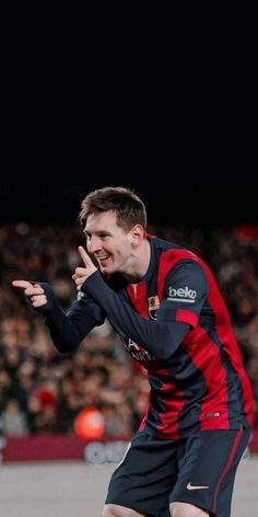 a man in black and red uniform playing soccer