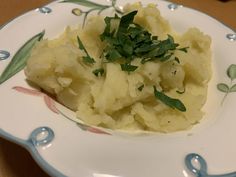 a white plate topped with mashed potatoes and parsley