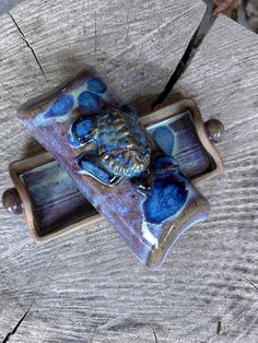 two ceramic objects sitting on top of a piece of wood next to a knife holder