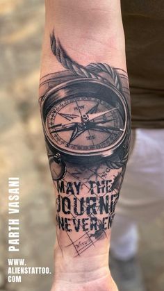 a man's arm with a compass tattoo on it and the words, may the journey never begin