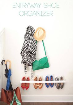 shoes, umbrellas and hats are hanging on the wall next to a coat rack