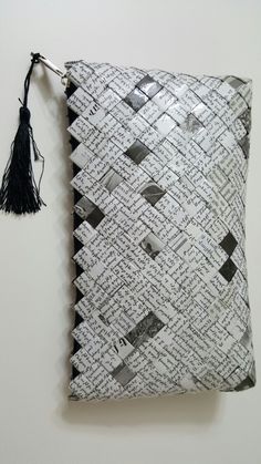 a white pillow with black and white designs on it, hanging from a tassel