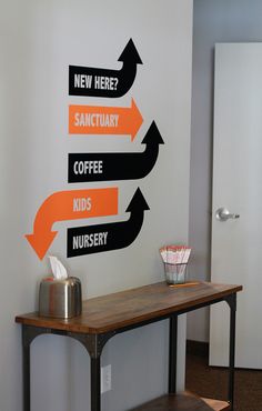 there is a sign on the wall that says new here, sancturary coffee kids nursery