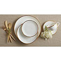 white and gold dinnerware set with flowers on the side, next to each other