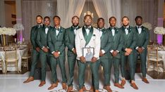 a group of men standing next to each other in front of a white table cloth