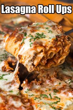 lasagna roll ups are being lifted from a casserole dish