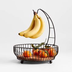 bananas and oranges in a metal fruit basket