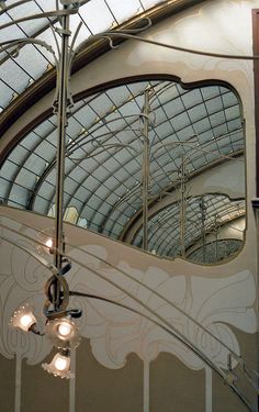 the inside of a building with many windows and lights hanging from it's ceiling