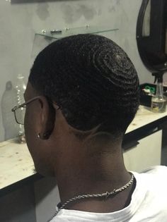 the back of a woman's head in front of a bathroom mirror and sink