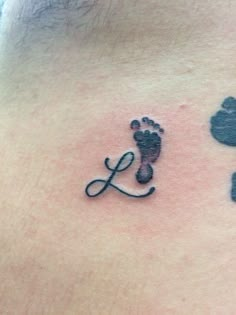 a tattoo with the letter l on it and an image of a person's foot