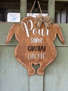 a wooden sign that says pour some gravy on me hanging from the side of a door