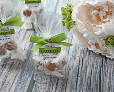 some candies wrapped in cellophane and tied with green ribbon on a wooden table