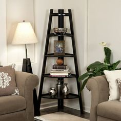 a corner shelf in the corner of a living room filled with books and vases