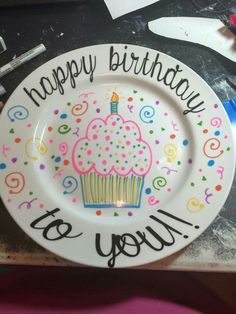 a happy birthday plate with a cupcake on it