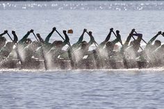 a large group of people riding on top of a boat in the middle of water